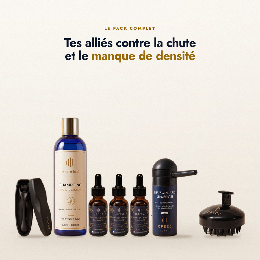 Les cinq produits du Pack Complet BREEZ alignés : le dermaroller, le shampoing, trois sérums, la fibre densifiante et la brosse