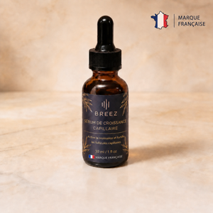 Flacon du sérum anti-chute BREEZ 30 ml sur un plan de marbre clair