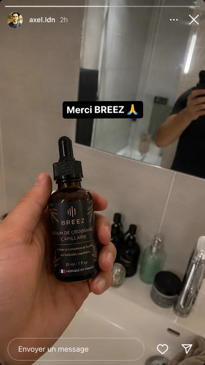 Membre de la communaute BREEZ tenant le flacon devant son miroir.
