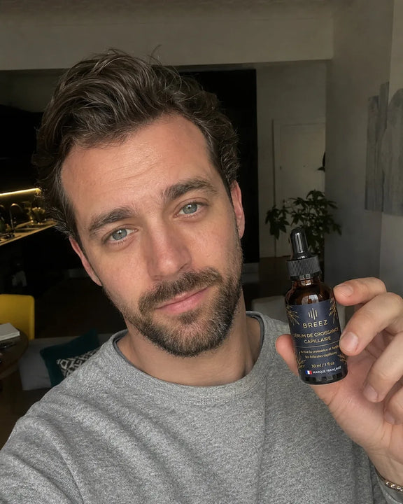 Membre de la communaute BREEZ tenant le flacon de serum dans son salon.